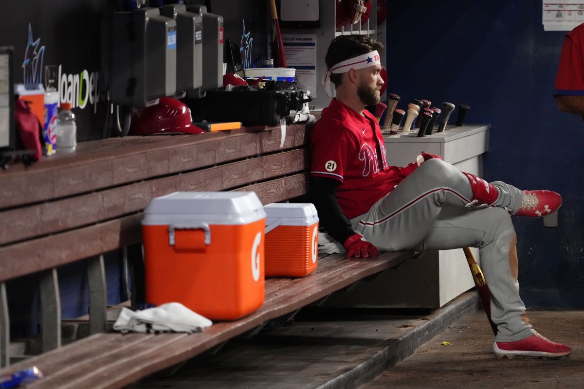 Philadelphia Phillies superstar Bryce Harper looks on in the dugout.