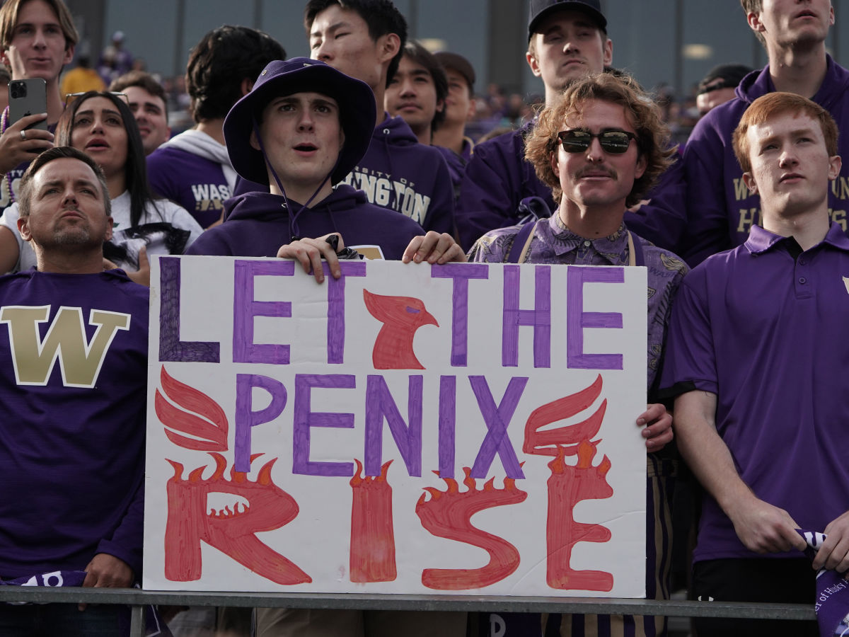 Fans hold up their own customized Penix sign.