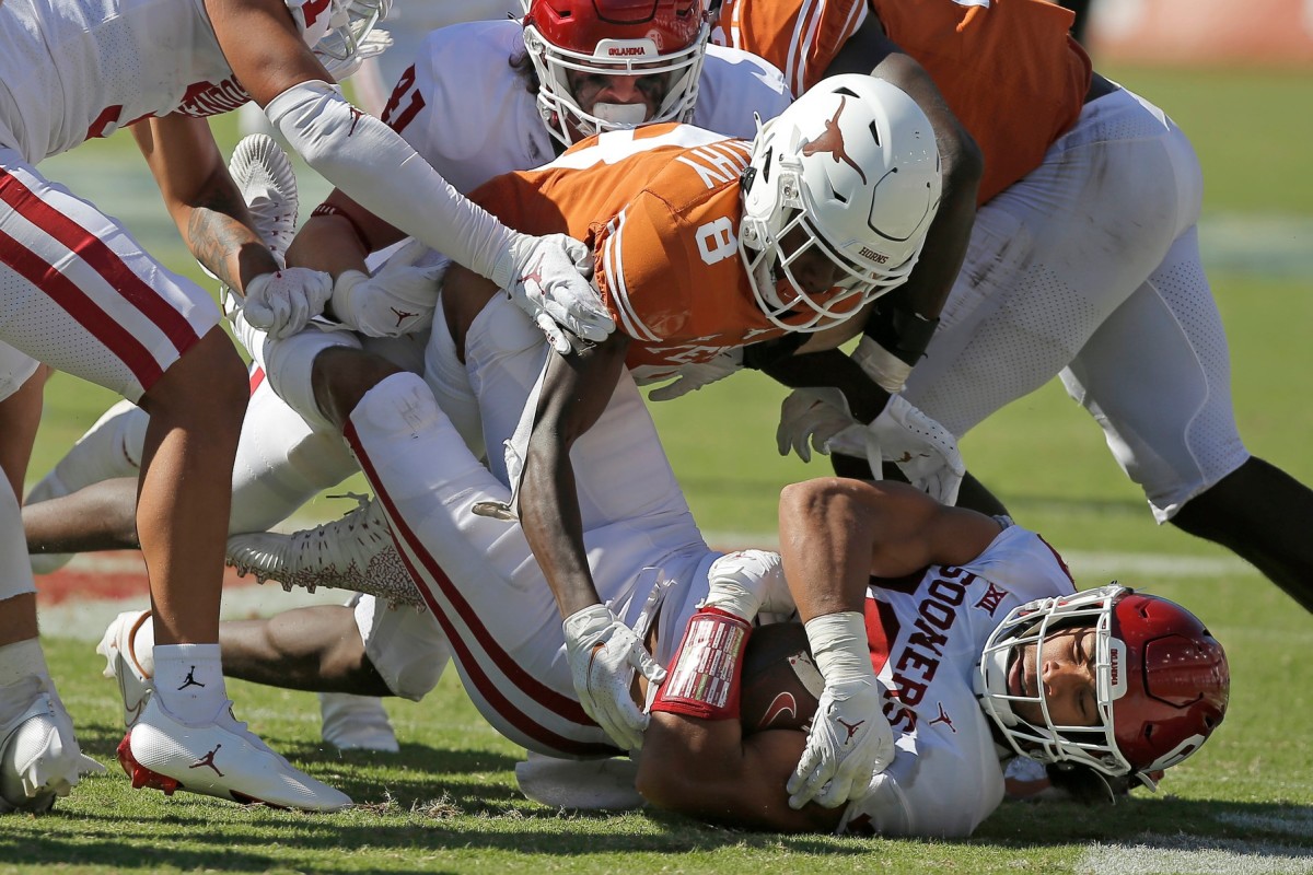 Oklahoma's Caleb Kelly (19) recovers a fumble under Texas' Xavier Worthy (8) during the Red River Showdown on Oct. 9 at the Cotton Bowl in Dallas. The Sooners won 55-48.