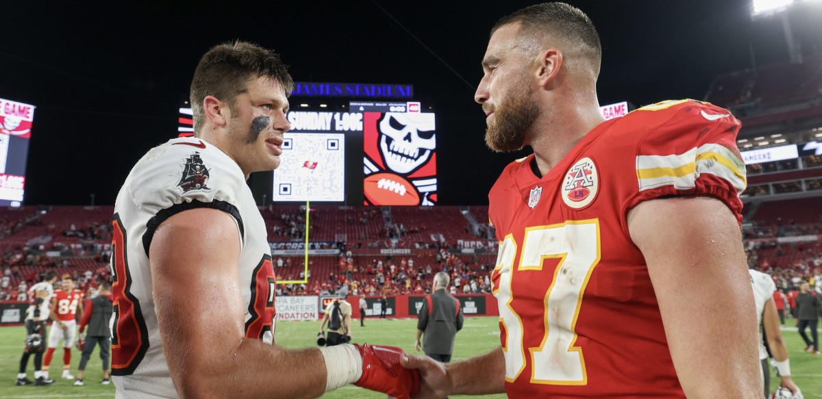 Cade Otton and Kansas City tight end Travis Kelce greet each other.