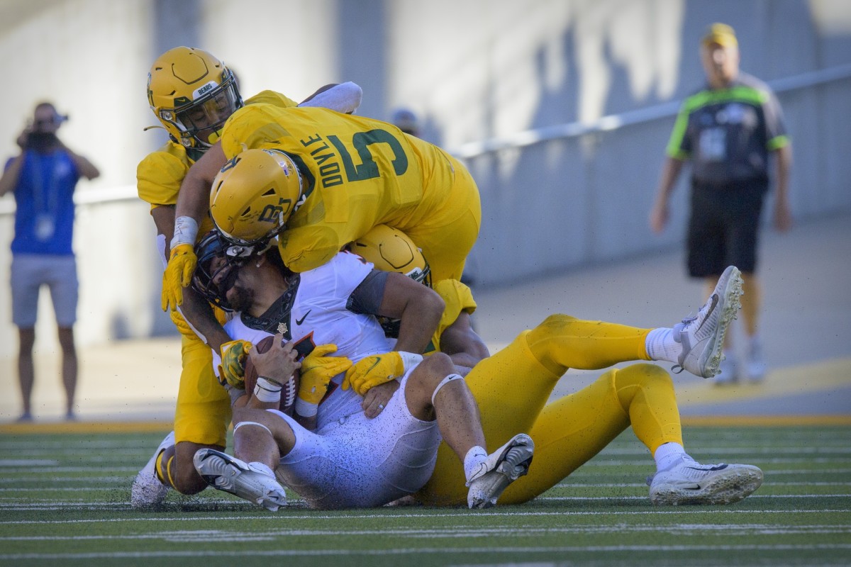 Oct 1, 2022; Waco, Texas, USA; Oklahoma State Cowboys quarterback Spencer Sanders (3) is sacked by Baylor Bears linebacker Garmon Randolph (55) and linebacker Dillon Doyle (5) during the second half at McLane Stadium.