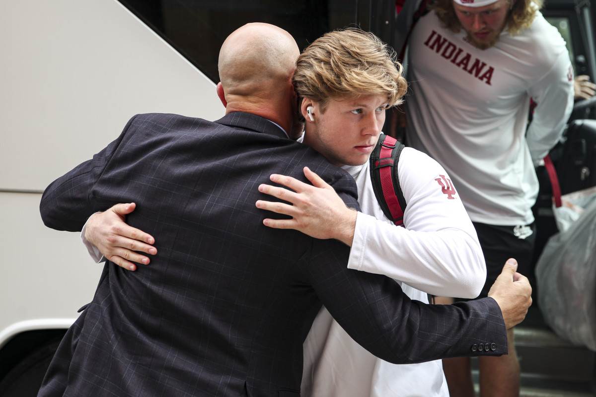 Indiana redshirt freshman linebacker Matt Hohlt hugs defensive coordinator Chad Wilt after getting off the bus before Indiana's game against Cincinnati at Nippert Stadium on Sept. 24