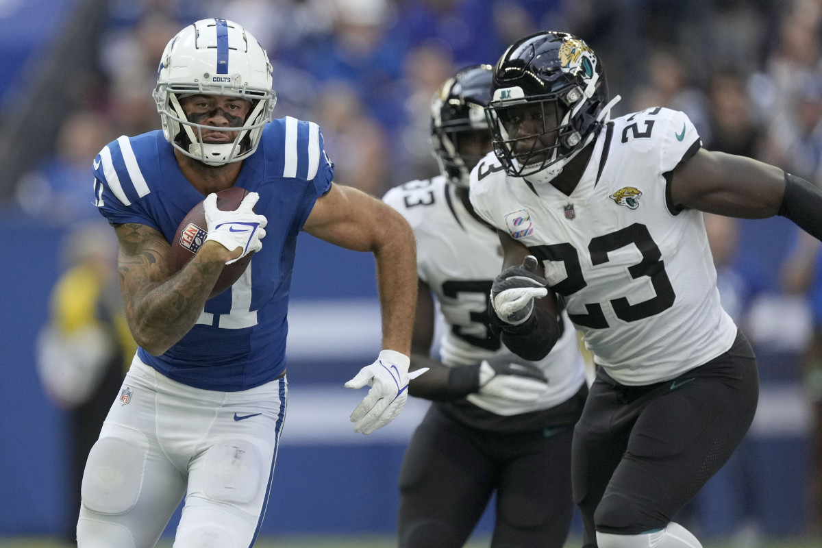 Oct 16, 2022; Indianapolis, Indiana, USA; Indianapolis Colts wide receiver Michael Pittman Jr. (11) rushes the ball as Jacksonville Jaguars linebacker Foyesade Oluokun (23) gives chase during the first half at Lucas Oil Stadium.
