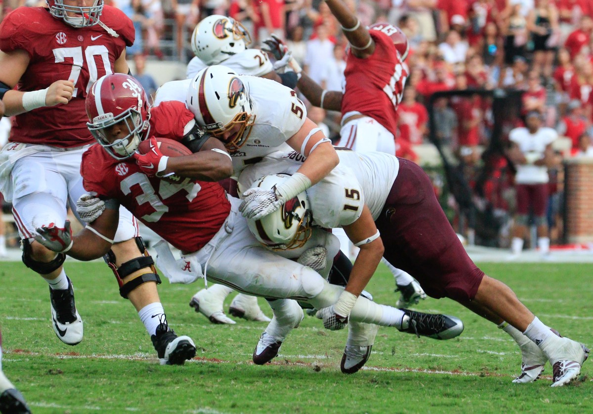 Alabama Crimson Tide running back Damien Harris (34) is tackled by Louisiana Monroe Warhawks linebacker Braxton Moore (15) and defensive lineman Colton Moorehead (52) at Bryant-Denny Stadium.