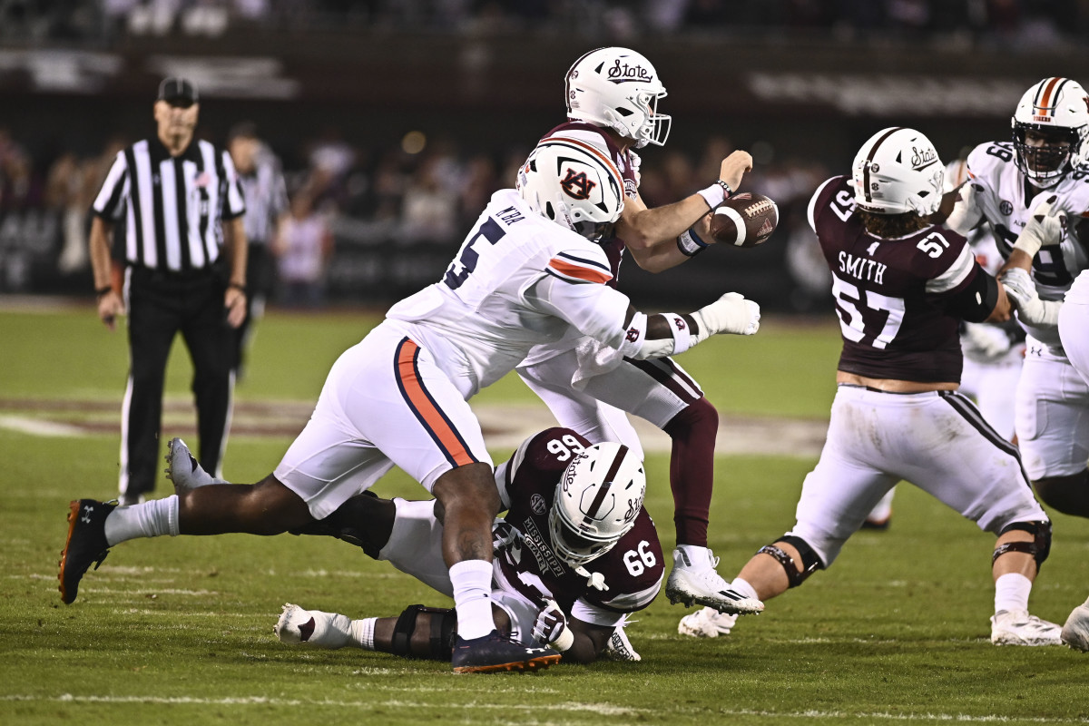 Nov 5, 2022; Starkville, Mississippi, USA; Auburn Tigers defensive lineman Jeffrey M'Ba (5) forces a fumble by Mississippi State Bulldogs quarterback Will Rogers (2) during the second quarter at Davis Wade Stadium at Scott Field. Mandatory Credit: Matt Bush-USA TODAY Sports