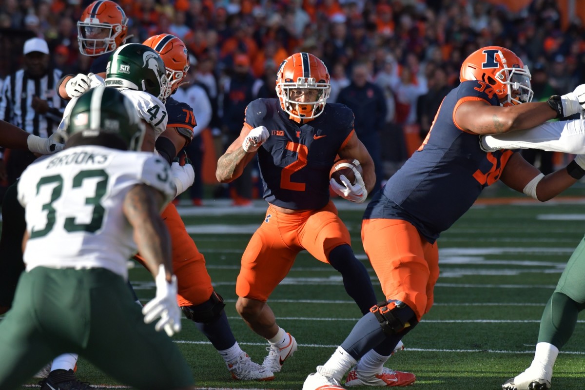 Nov 5, 2022; Champaign, Illinois, USA; Illinois Fighting Illini running back Chase Brown (2) runs through an opening against the Michigan State Spartans during the first half at Memorial Stadium.