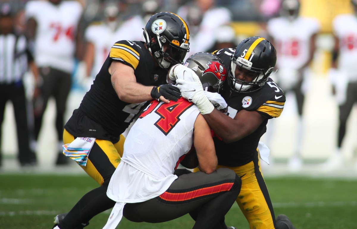 Cameron Brate (84) of the Tampa Bay Buccaneers gets wrapped up for a tackle by Robert Spillane (41) and linebacker Myles Jack (51) of the Pittsburgh Steelers. © Michael Longo/For USA Today Network / USA TODAY NETWORK