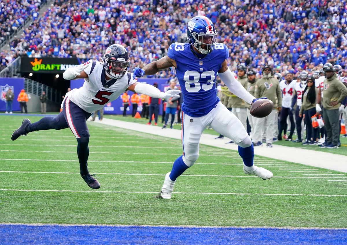 Nov 13, 2022; East Rutherford, NJ, USA; New York Giants tight end Lawrence Cager (83) scores a touchdown as Houston Texans safety Jalen Pitre (5) defends during the first quarter at MetLife Stadium.