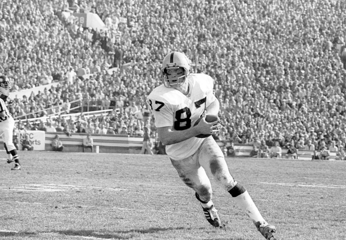 Oakland Raiders tight end Dave Casper, left, carries the ball