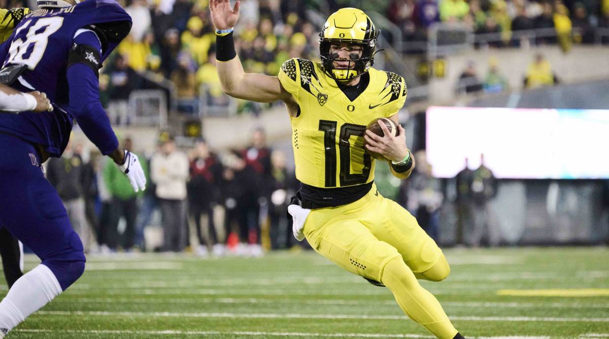 Oregon quarterback Bo Nix runs with the ball in a game vs. Washington.