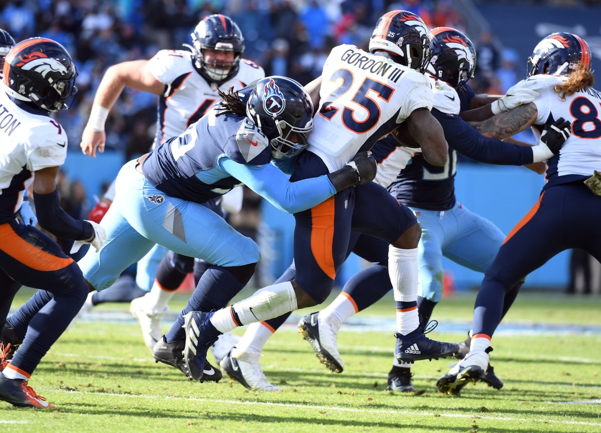 Tennessee Titans defensive end Denico Autry (96) tackles Denver Broncos running back Melvin Gordon III (25) after a short gain during the second half at Nissan Stadium.