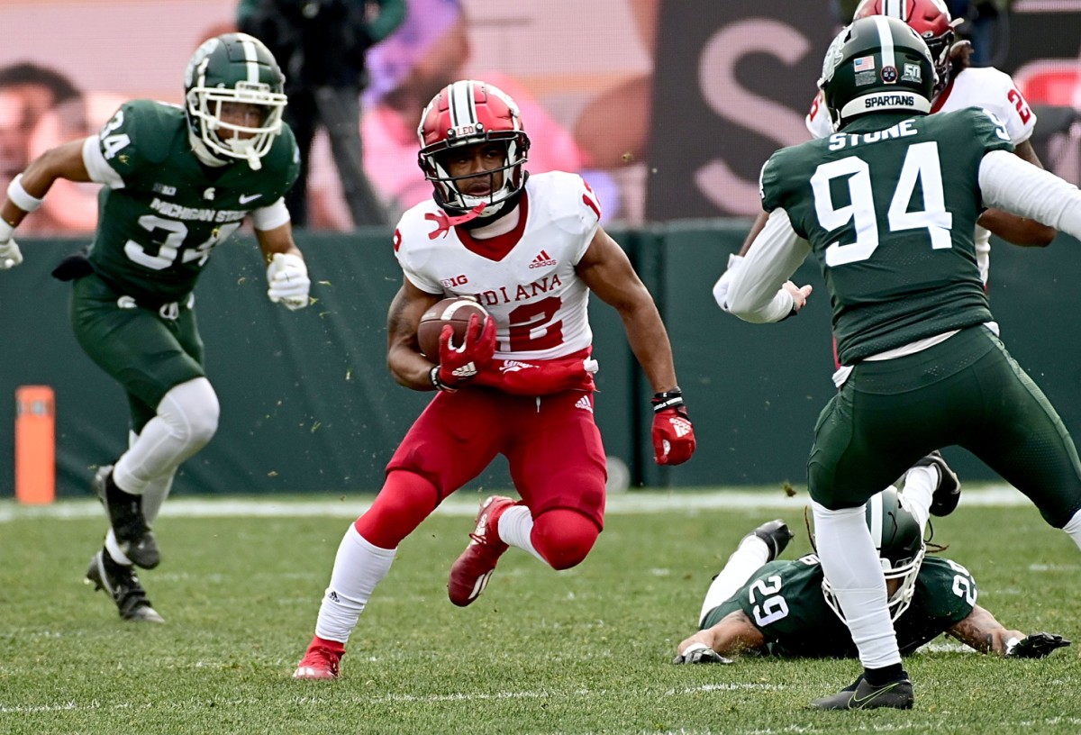 Indiana Hoosiers running back Jaylin Lucas (12) sprints upfield through the Michigan State Spartans defense at Spartan Stadium.