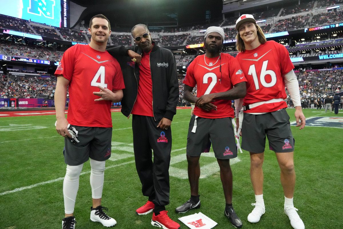 Derek Carr, Snoop Dog, Tyler Huntley and Trevor Lawrence pose on the field