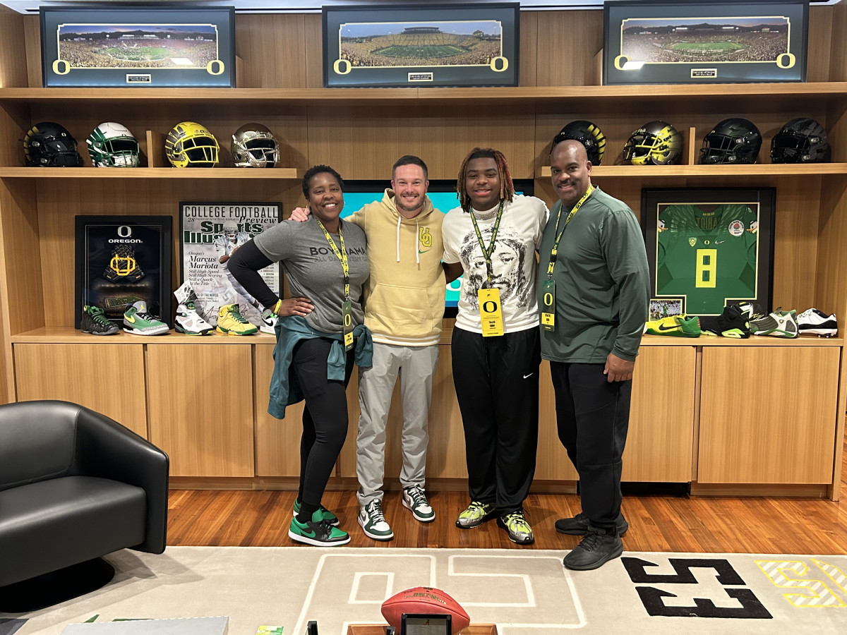 Trajen Odom pictured with his parents and Dan Lanning.