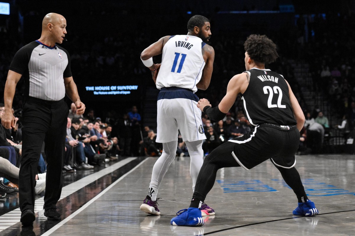 Dallas Mavericks guard Kyrie Irving (11) controls the ball while being defended by Brooklyn Nets forward Jalen Wilson (22)