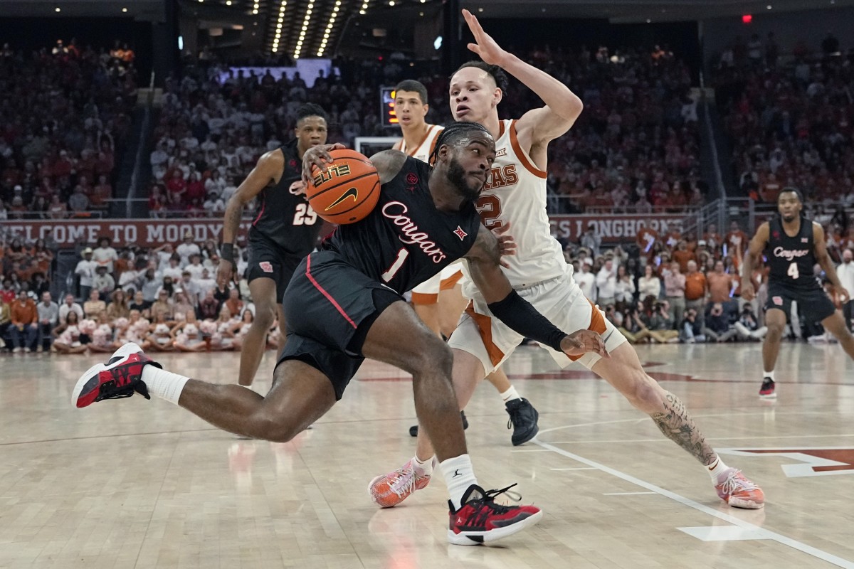 Houston Cougars guard Jamal Shead (1) drives to the basket while defended by Texas Longhorns guard Chendall Weaver (2) during the second half at Moody Center. 