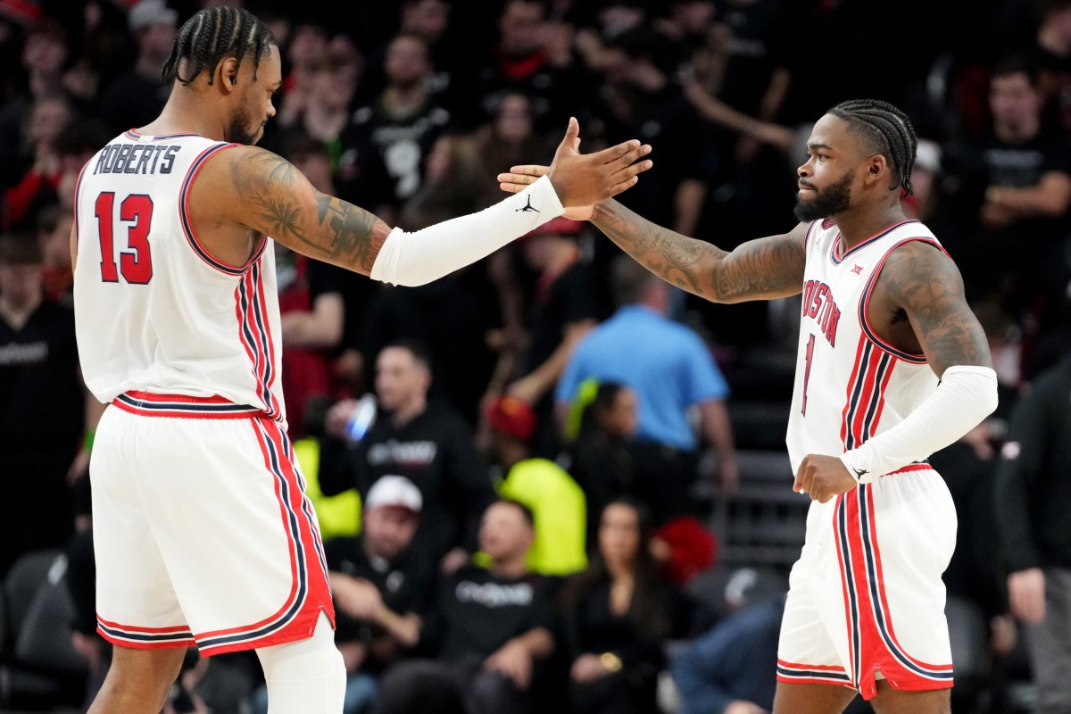 Houston Cougars forward J'Wan Roberts (13) and Houston Cougars guard Jamal Shead (1) celebrate the win at the conclusion of the second half of an NCAA college basketball game against the Cincinnati Bearcats, Saturday, Feb. 10, 2024, at Fifth Third Arena in Cincinnati.