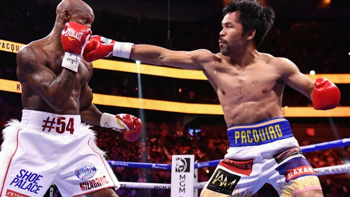 Manny Pacquiao (R) throws punch at Yordenis Ugas during their WBA welterweight title fight at T-Mobile Arena in Las Vegas, Nevada. Manny Pacquiao recieves shock disqualification from Olympic organizers. ETHAN MILLER/GETTY IMAGES. 