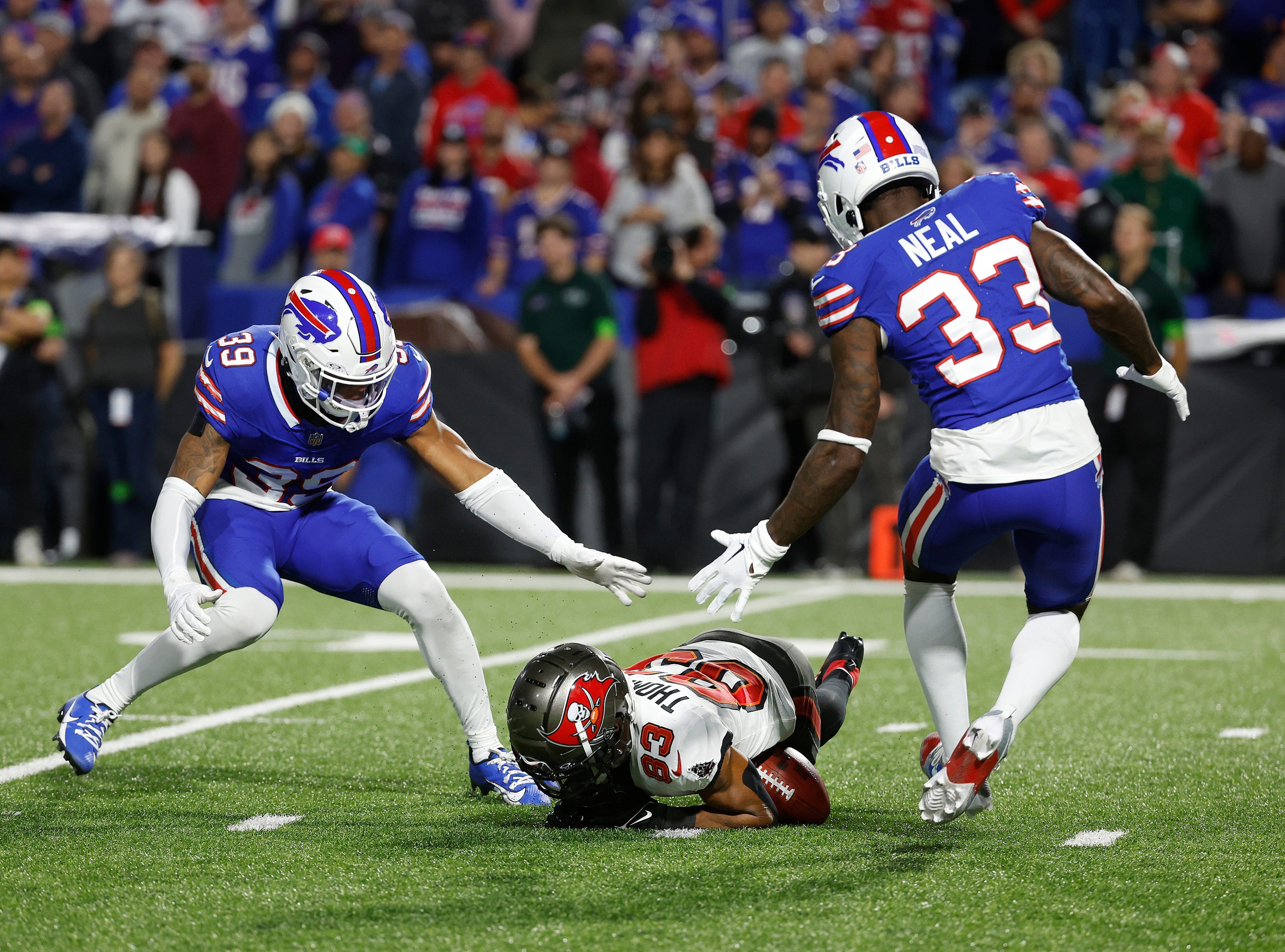 Tampa Bay Buccaneers wide receiver Deven Thompkins (83) recovers his own fumble on this punt return against Buffalo Bills cornerback Cam Lewis (39) and Buffalo Bills cornerback Siran Neal (33).