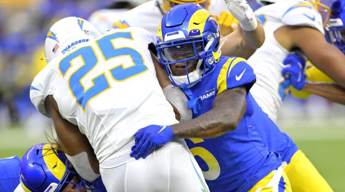 Rams cornerback Tre Tomlinson tackles Chargers running back Joshua Kelley during a preseason game