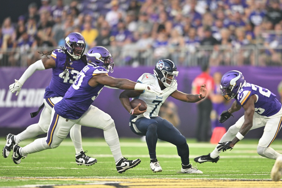 Minnesota Vikings defensive end Esezi Otomewo (90) and cornerback Andrew Booth Jr. (23) and linebacker Luiji Vilain (43) prepare to tackle Tennessee Titans quarterback Malik Willis (7) during the first quarter at U.S. Bank Stadium.