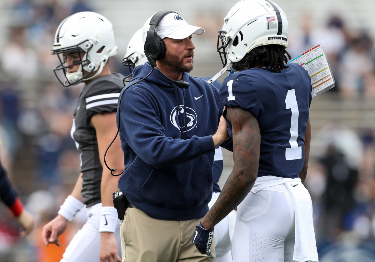 Penn State offensive coordinator Mike Yurcich talks with receiver KeAndre Lambert-Smith during the 2023 Blue-White Game at Beaver Stadium.