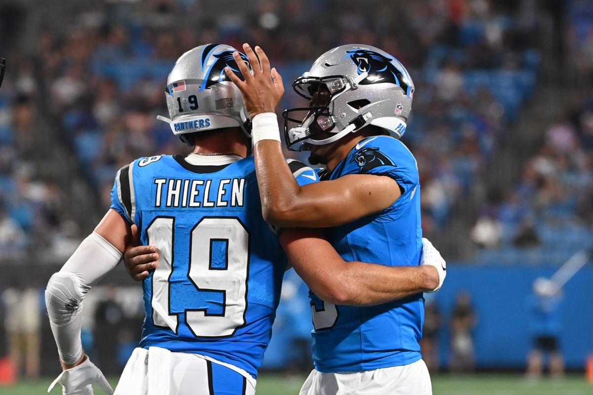 Adam Thielen embraces Bryce Young, who taps his helmet in celebration