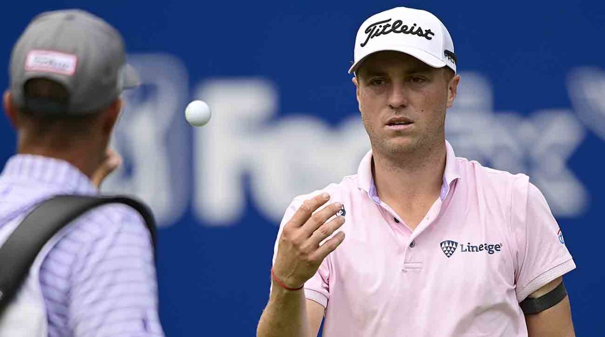 Justin Thomas tosses his ball to his caddie  during the final round of the 2023 Wyndham Championship.