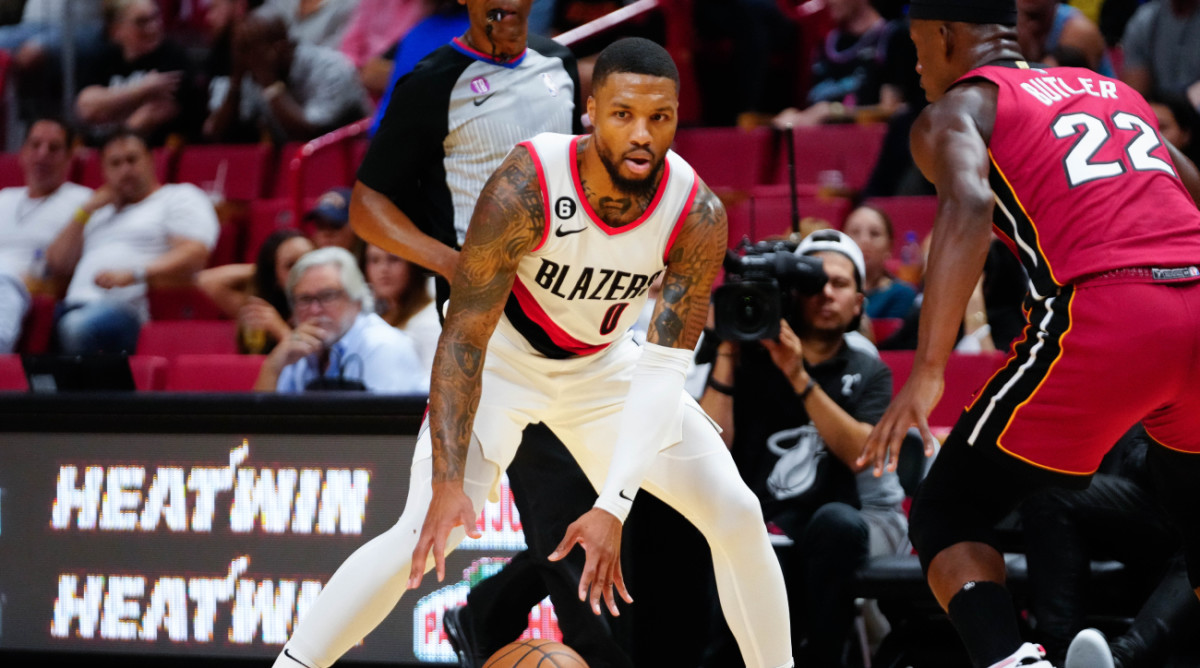 Trail Blazers guard Damian Lillard dribbles against Heat wing Jimmy Butler.