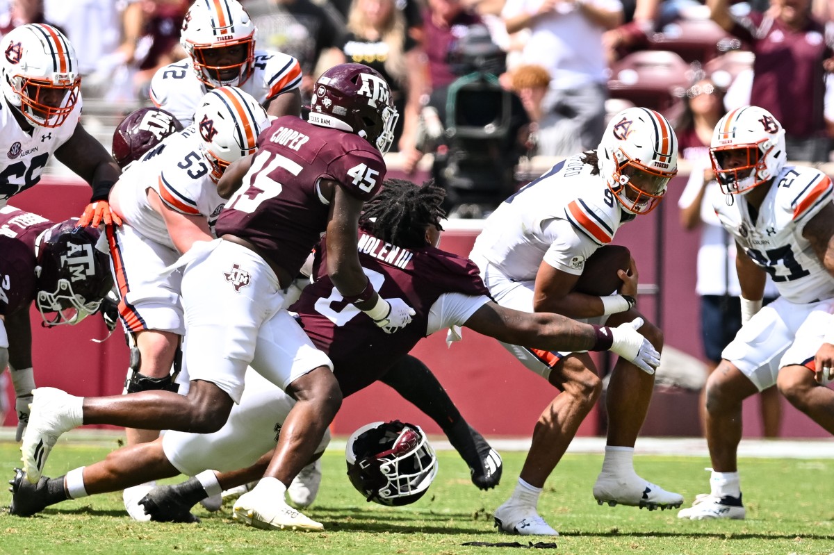 Sep 23, 2023; College Station, Texas, USA; Texas A&M Aggies defensive lineman Walter Nolen (0) and linebacker Edgerrin Cooper (45) tackle Auburn Tigers quarterback Robby Ashford (9) for a loss during the third quarter at Kyle Field. Mandatory Credit: Maria Lysaker-USA TODAY Sports  