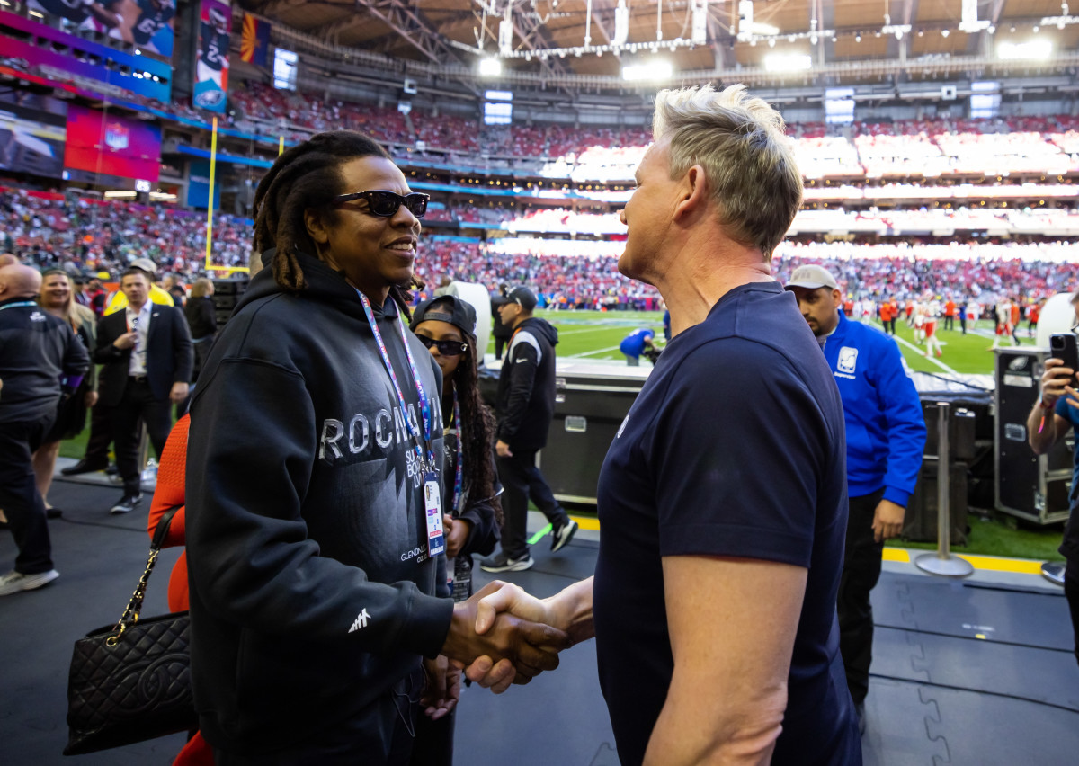 Recording artist Jay-Z (left) greets celebrity chef Gordon Ramsay on the sideline before Super Bowl LVII at State Farm Stadium