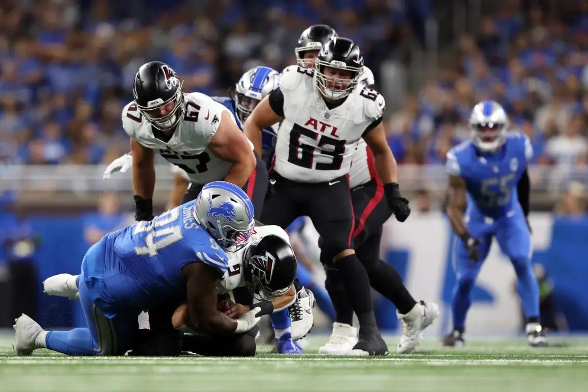 Atlanta Falcons quarterback Desmond Ridder tackled by Detroit Lions defensive lineman Benito Jones.