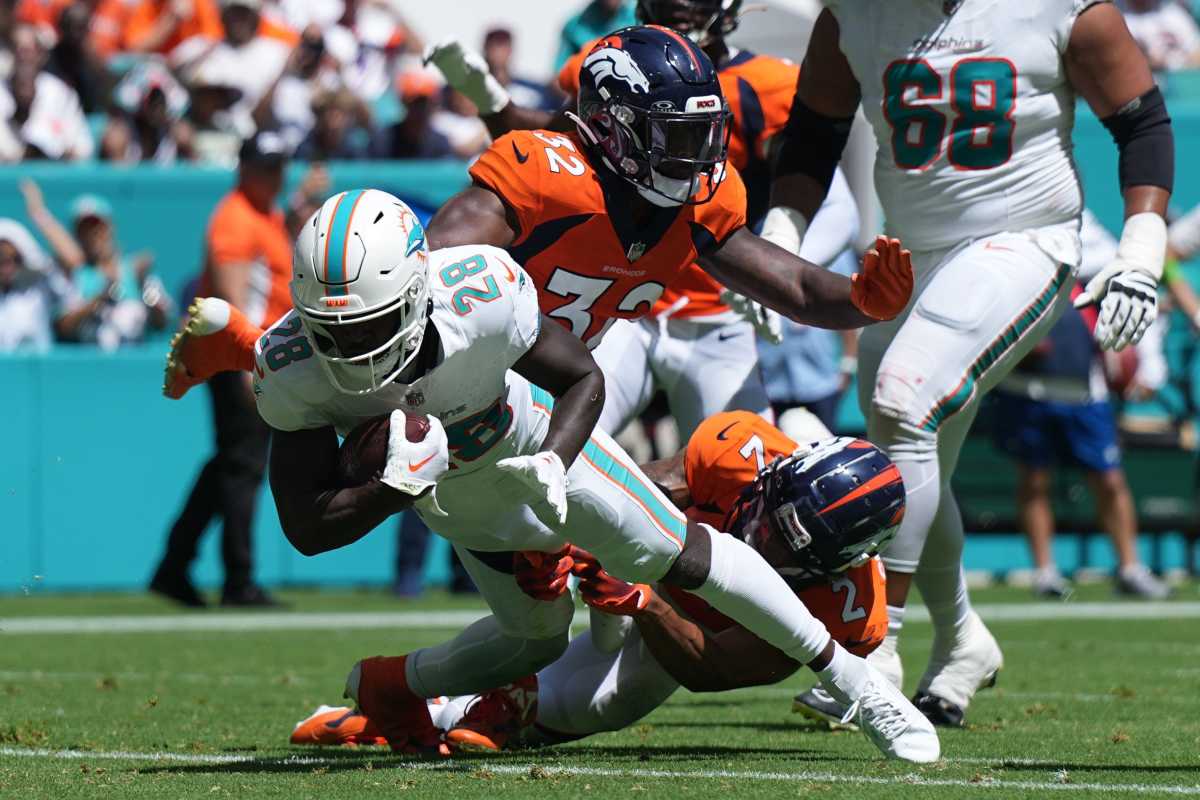 Miami Dolphins running back De'Von Achane (28) scores a touchdown in the second quarter as Denver Broncos cornerback Pat Surtain II (2) and safety Delarrin Turner-Yell (32) try to make the tackle on the play during the first half of an NFL game at Hard Rock Stadium in Miami Gardens, Sept. 24, 2023. 