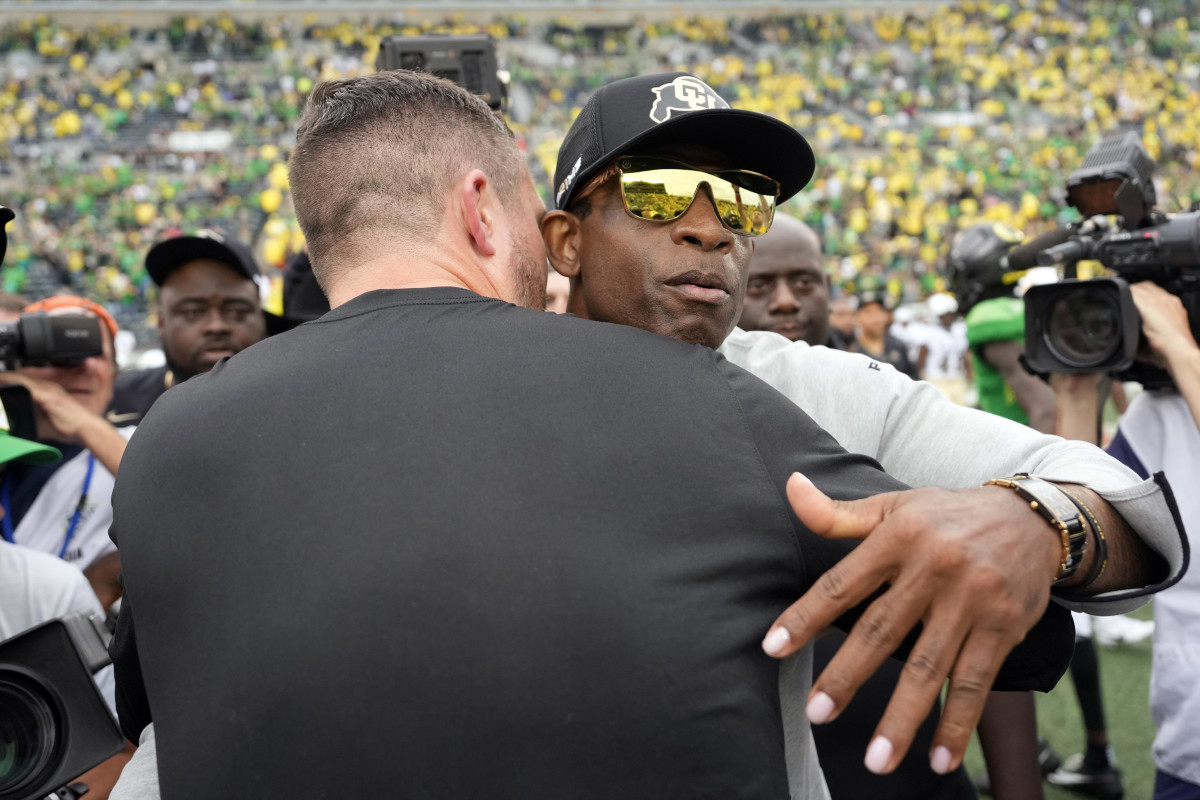 Oregon Ducks head coach Dan Lanning (left) and Colorado Buffaloes head coach Deion Sanders hug after the game at Autzen Stadium