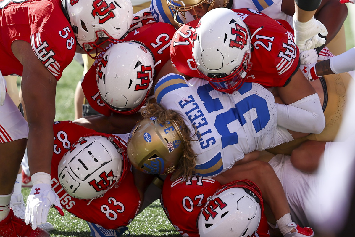 Sep 23, 2023; Salt Lake City, Utah, USA; UCLA Bruins running back Carson Steele (33) is tackled by five Utah Utes in the second half at Rice-Eccles Stadium. Mandatory Credit: Rob Gray-USA TODAY Sports