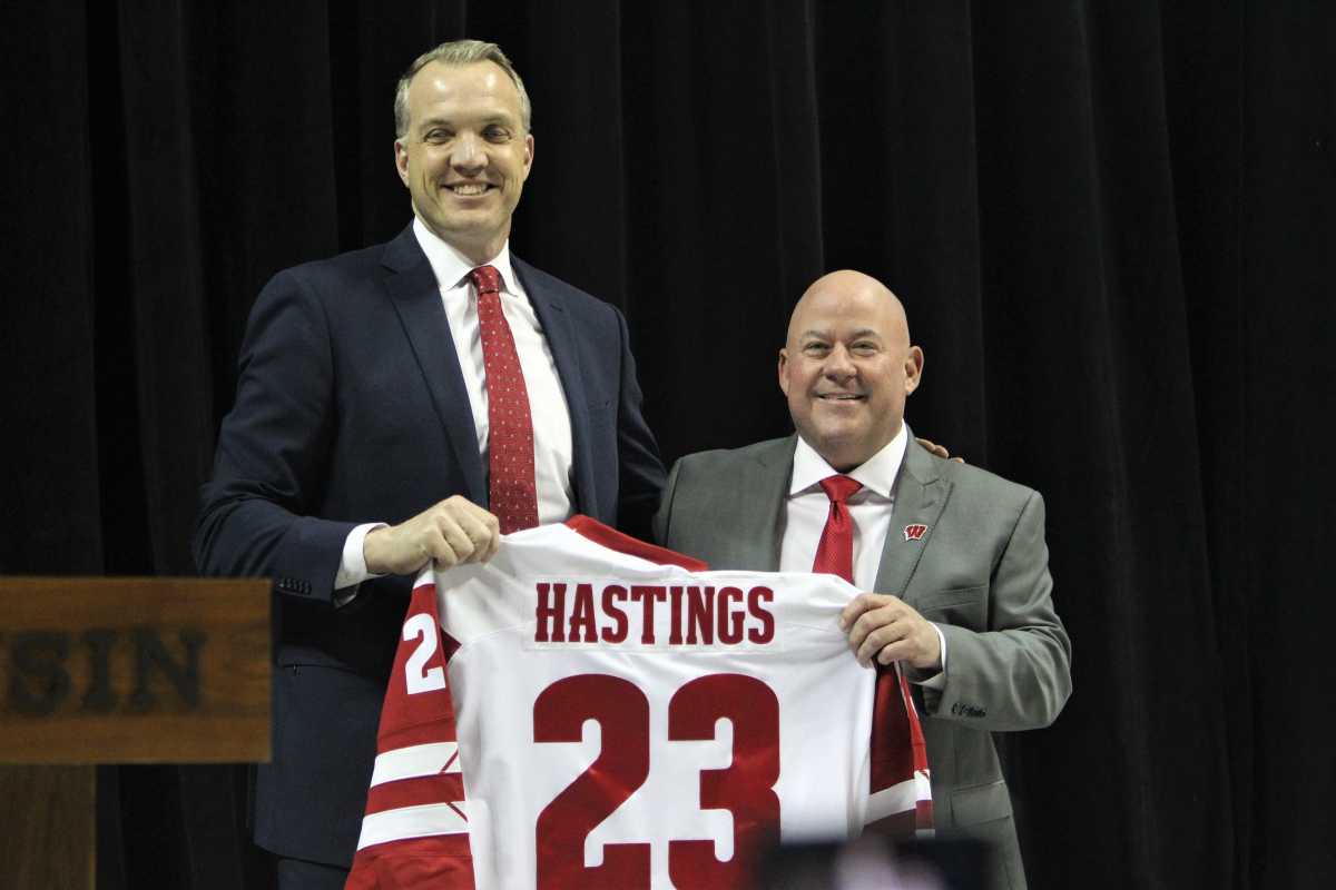 Wisconsin director Chris McIntosh (left) and men's hockey coach Mike Hastings' pose for a picture after Hastings' receives a Badgers jersey during his introductory press conference Monday April 3, 2023 at the Kohl Center in Madison, Wis. Mike Hastings Into Press Conference 1 April 3 2023