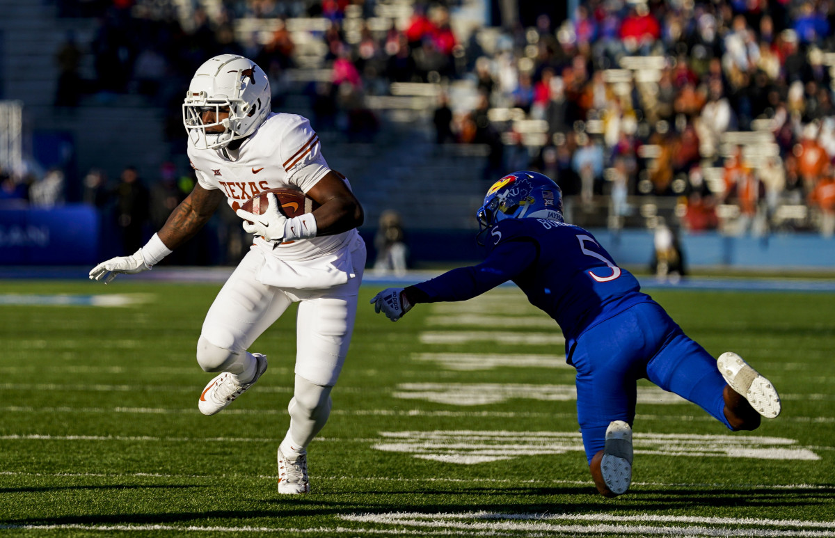 Texas Longhorns wide receiver Savion Red (17) runs with the ball past Kansas Jayhawks safety O.J. Burroughs (5) during the first half at David Booth Kansas Memorial Stadium.