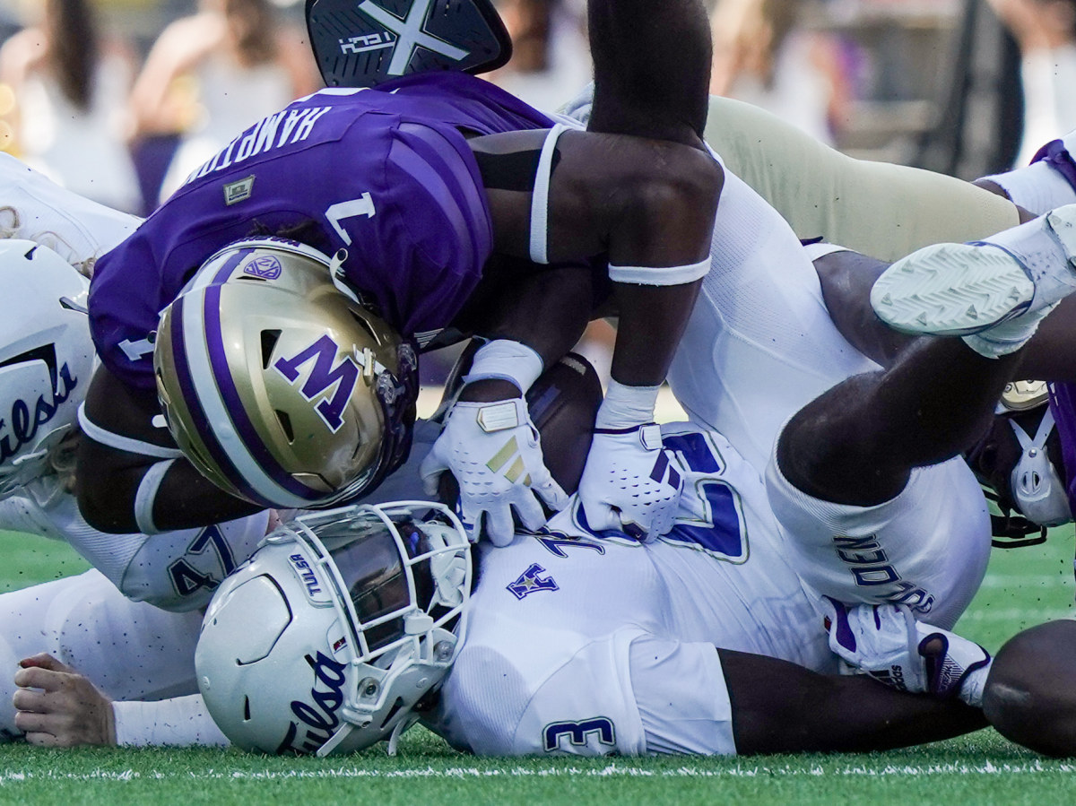 Dom Hampton, the UW's leading tackler, drops a Tulsa player with a big hit.