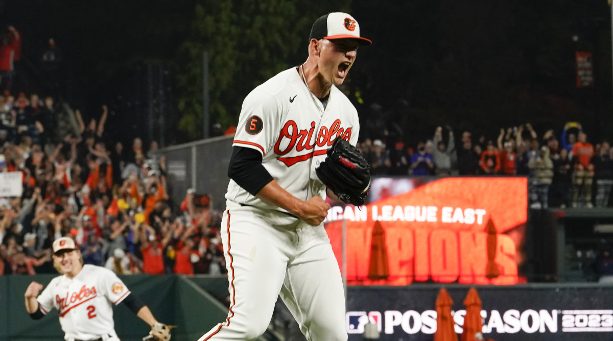 Orioles starting pitcher Tyler Wells, right, reacts after recording the final out in a victory over the Boston Red Sox to win the 2023 AL East championship