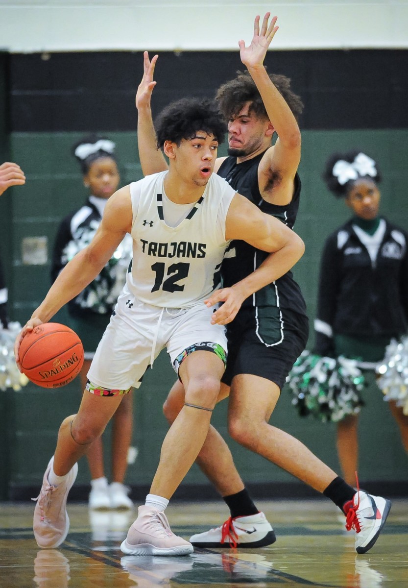 Wauwatosa West center Kai Rogers (12) handles the ball against the defense of West Allis Hale forward Robert Peters (32) in a game Friday, February 10, 2023, at Wauwatosa West High School in Wauwatosa, Wisconsin.