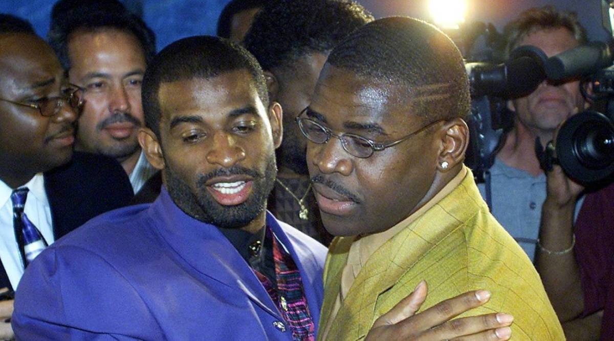 Former Cowboys teammates Deion Sanders and Michael Irvin embrace in 2000, after Irvin announces his retirement from the NFL.