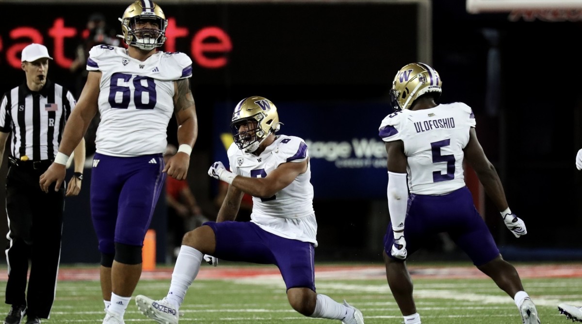 Ulumoo Ale (68) and Edefuan Ulofoshio (5) celebrate Bralen Trice's first sack of the season.