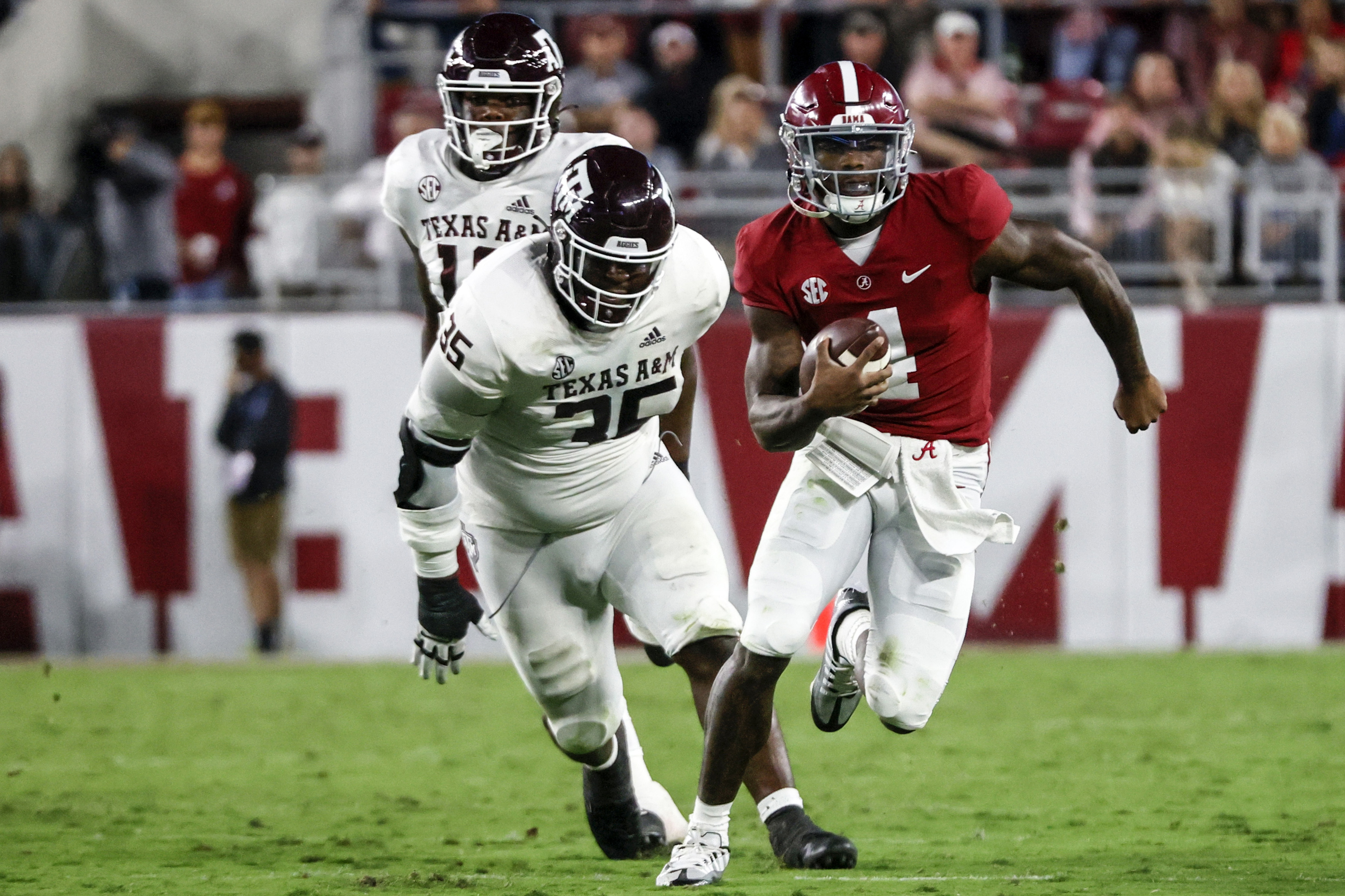 Alabama Crimson Tide quarterback Jalen Milroe (4) scrambles away from Texas A&M Aggies defensive lineman McKinnley Jackson (35) during the first half at Bryant-Denny Stadium.