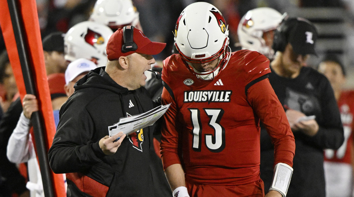 Louisville head coach Jeff Brohm gives instructions to quarterback Jack Plummer on the sideline