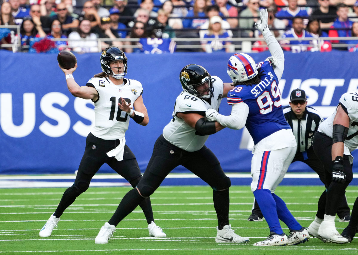 Trevor Lawrence throws the ball as his o-line blocks a Bills pass rusher