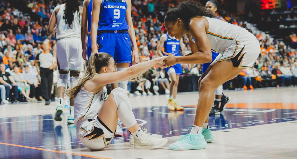 Laney (R) helps Ionescu up during the Liberty's victorious Game 4 showdown against the Connecticut Sun on Oct. 1