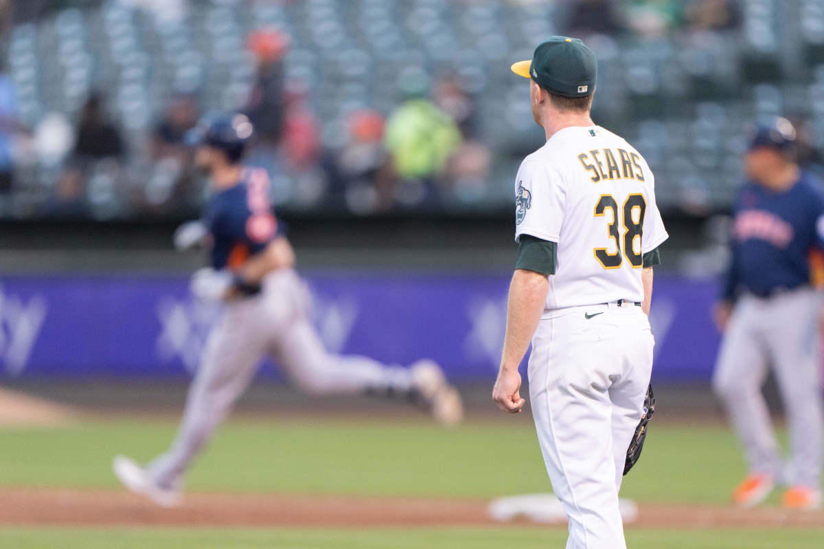 Oakland Athletics pitcher Frankie Montas, center, hands the ball