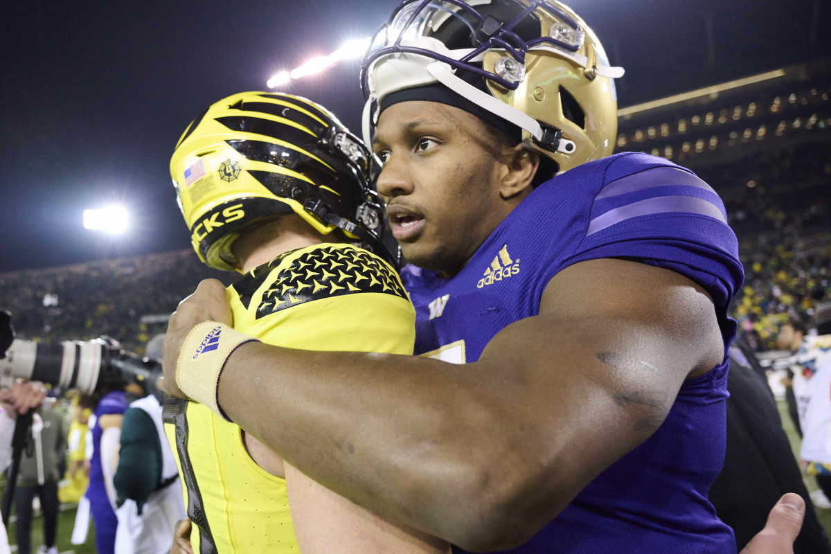 Nov 12, 2022; Eugene, Oregon, USA; Washington Huskies quarterback Michael Penix Jr. (9) embraces Oregon Ducks quarterback Bo Nix (10) after a game at Autzen Stadium. The Huskies won the game 37-34. Mandatory Credit: Troy Wayrynen-USA TODAY Sports