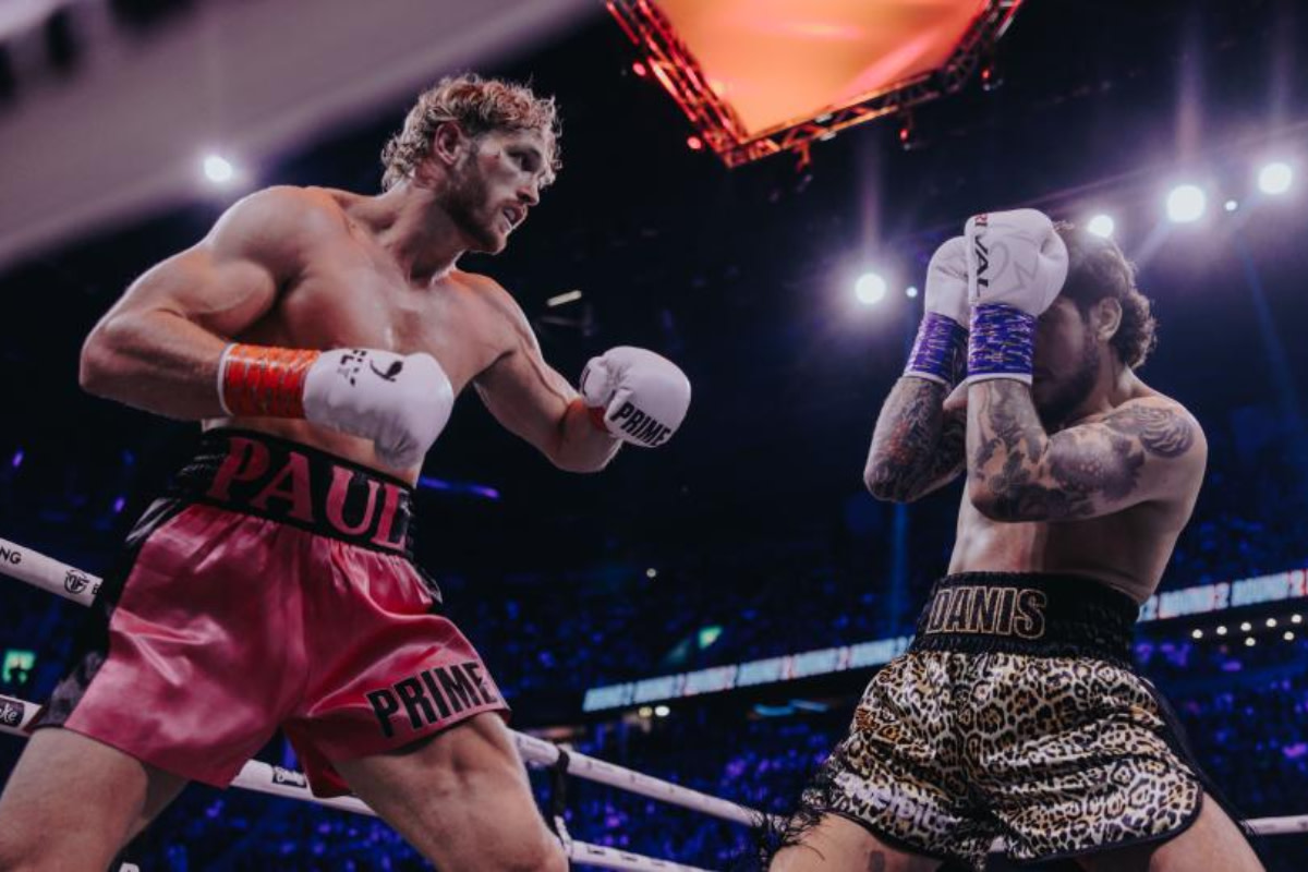 Logan Paul looks to throw a punch at a blocking Dillon Danis during their boxing fight.