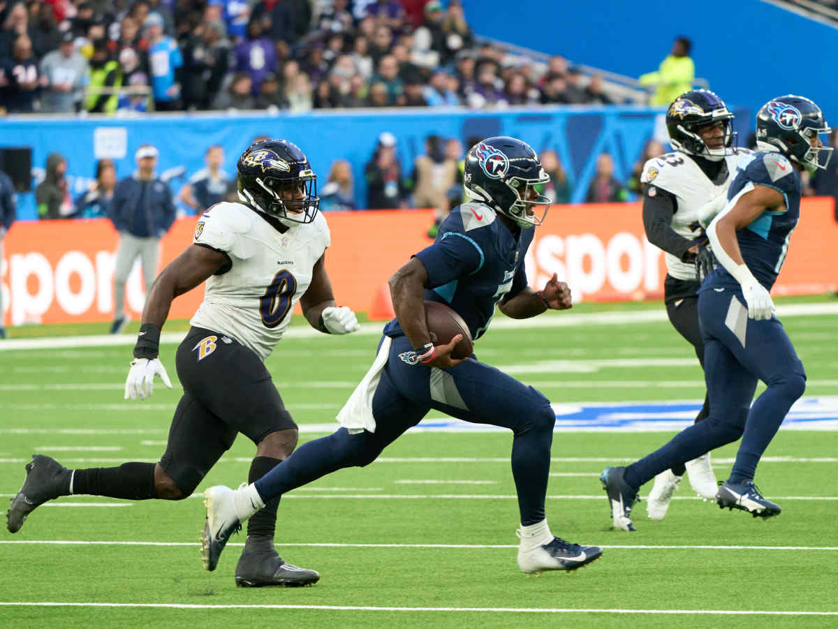 Malik Willis runs with the ball under one arm as a ravens player chases him